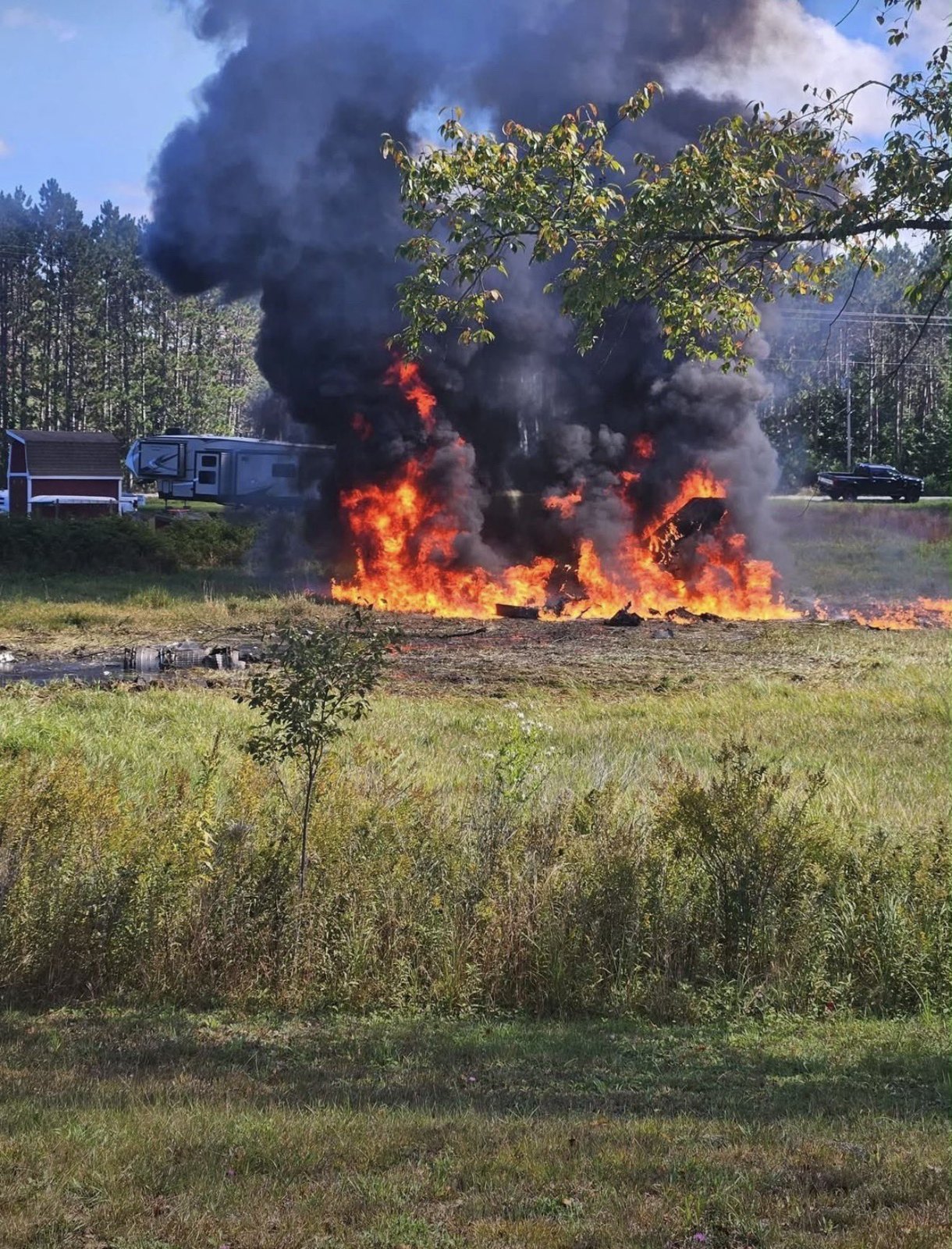 Flames and heavy black smoke rise from the F-16 crash site in Grand Traverse County