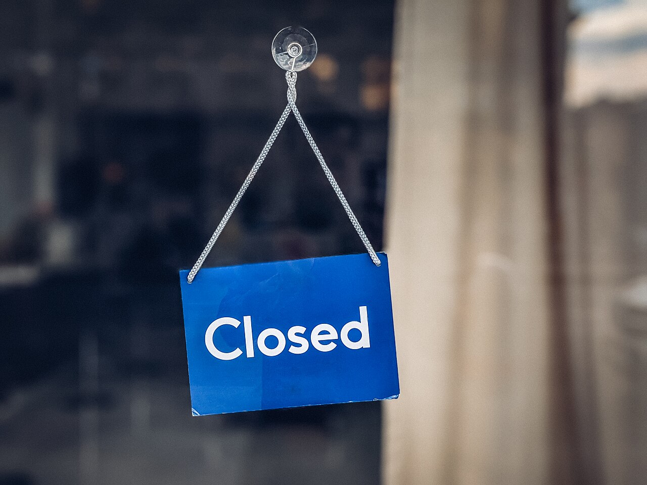 A closed sign hanging in a store door